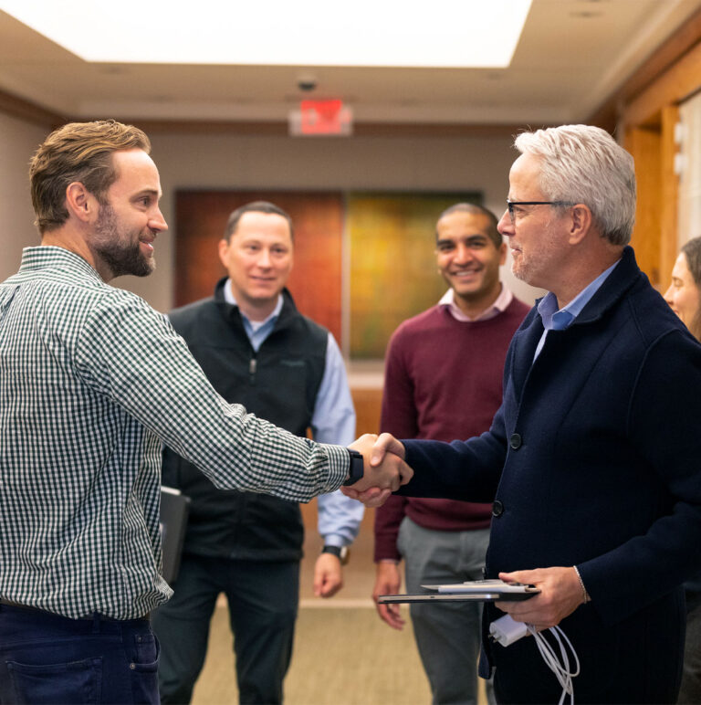 Colleagues greeting one another in a photograph from Berkshire Partners’ company history