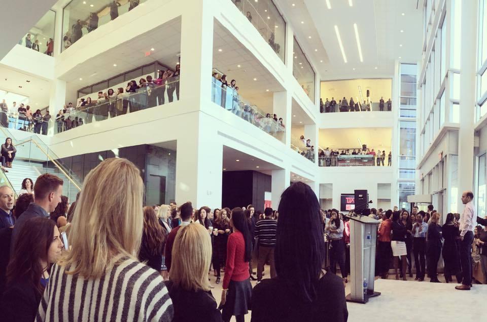 TJX Canada employees gather across the floors and balconies of a bright office foyer for a talk by founder Ben Cammarata.