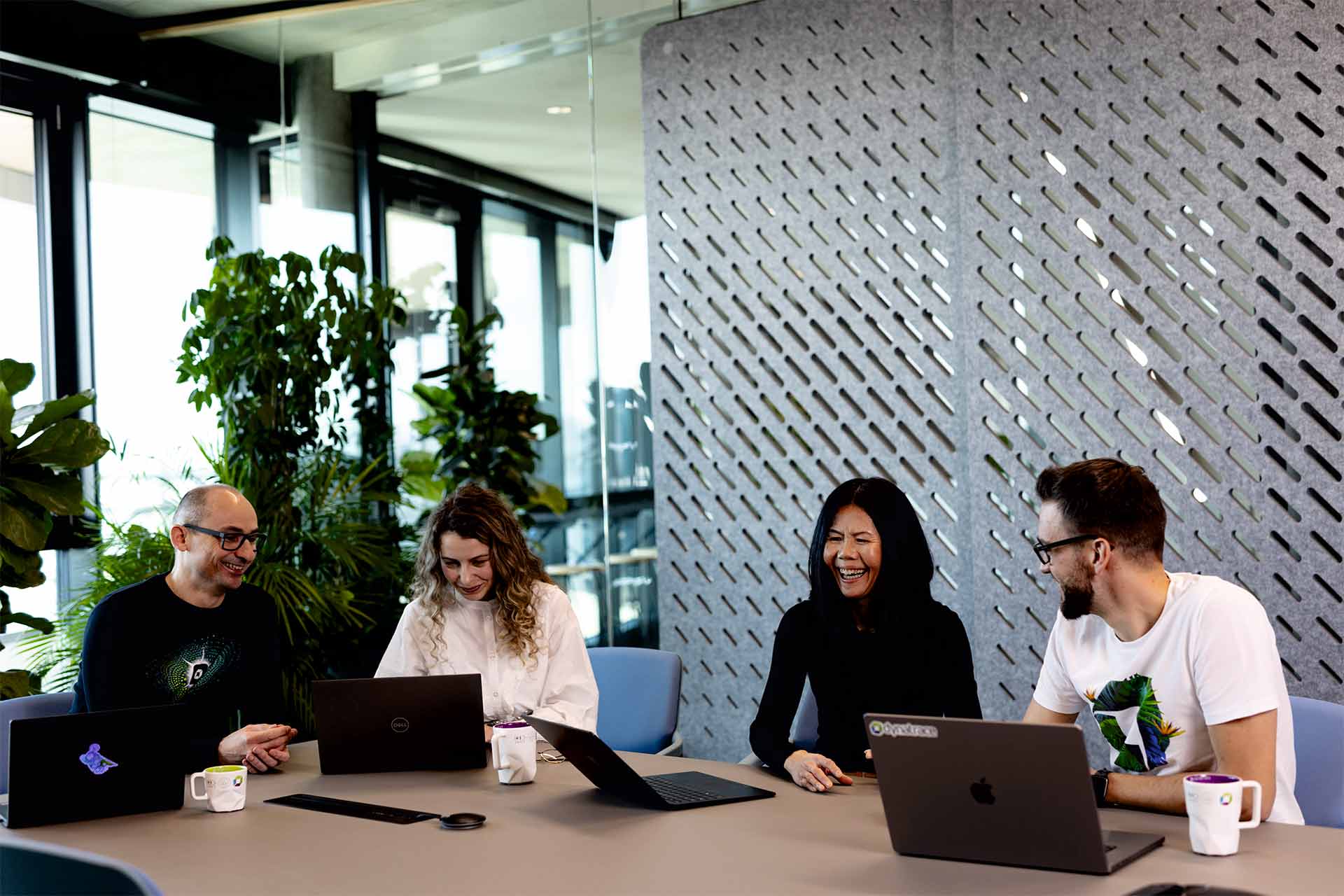 Bernd Greifeneder and Sok-Kheng Taing with two colleagues around laptops at a table