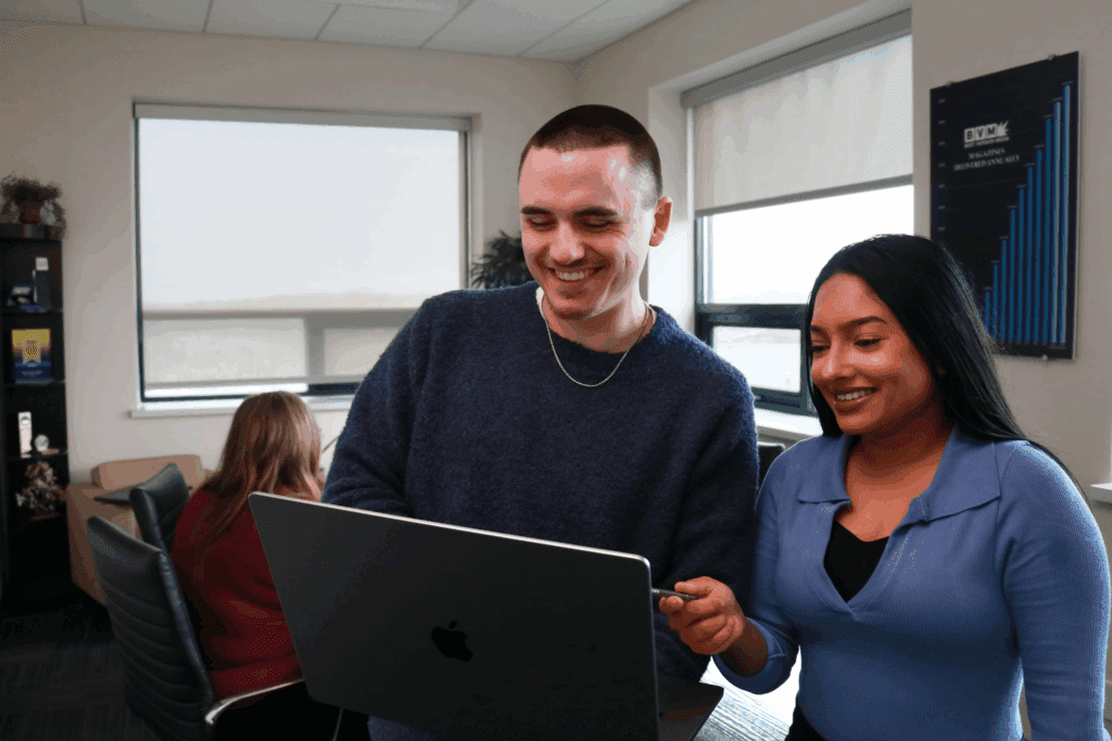 Best Version Media team members collaborating around a laptop at the Brookfield office