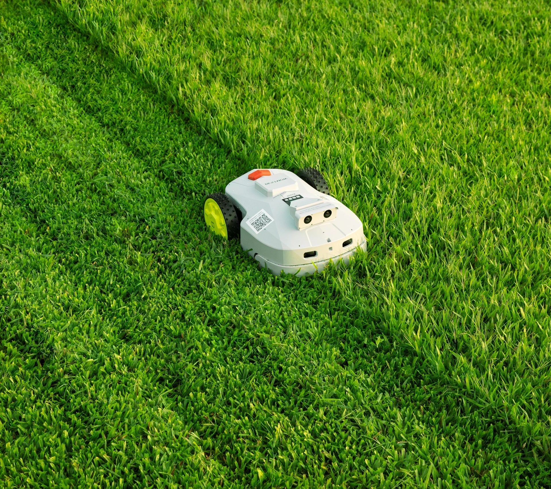 BESTMOW T-100 robotic mower cutting a green lawn