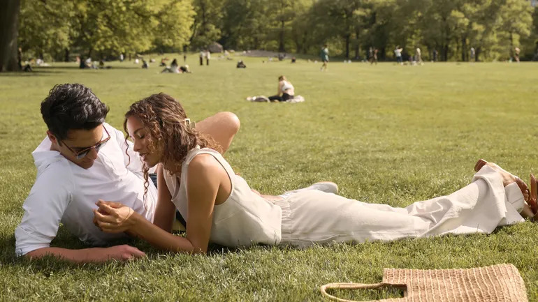 A couple relaxes on the grass in a New York park in Rhone's A Love Letter to NYC campaign