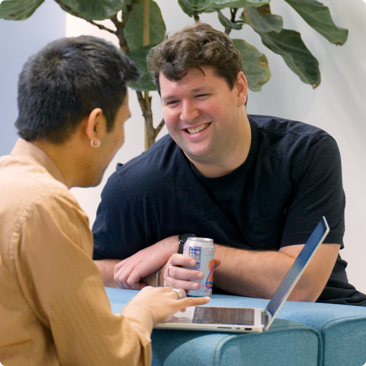 Colleagues talking beside an open laptop in a Betterment careers photograph