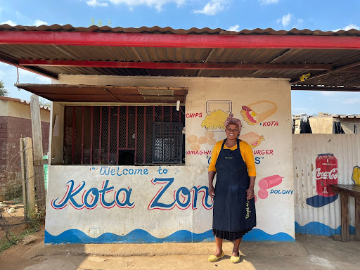 Phindi standing outside her painted township food shop