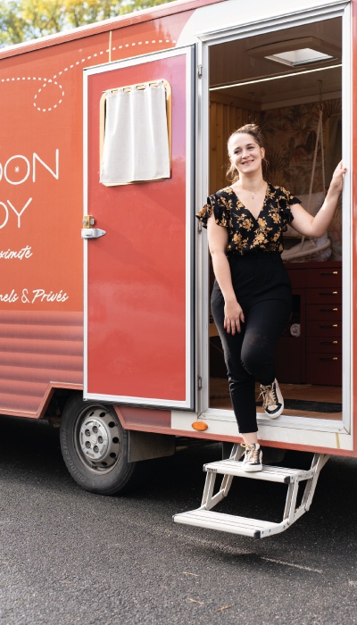 Élodie Sohier standing in the doorway of her orange Cocoon de Soy beauty truck
