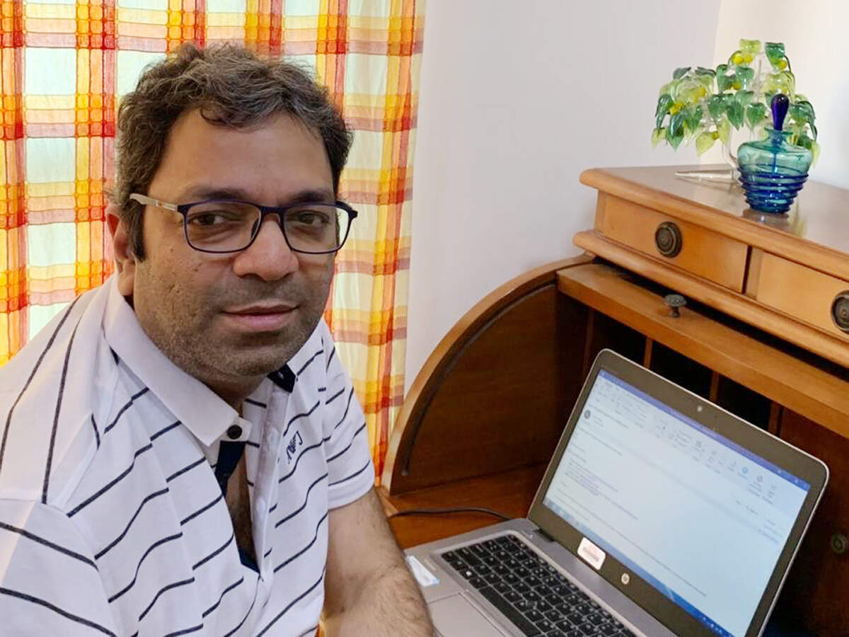 Bharath Sastry seated beside his wooden desk and laptop at home in 2020