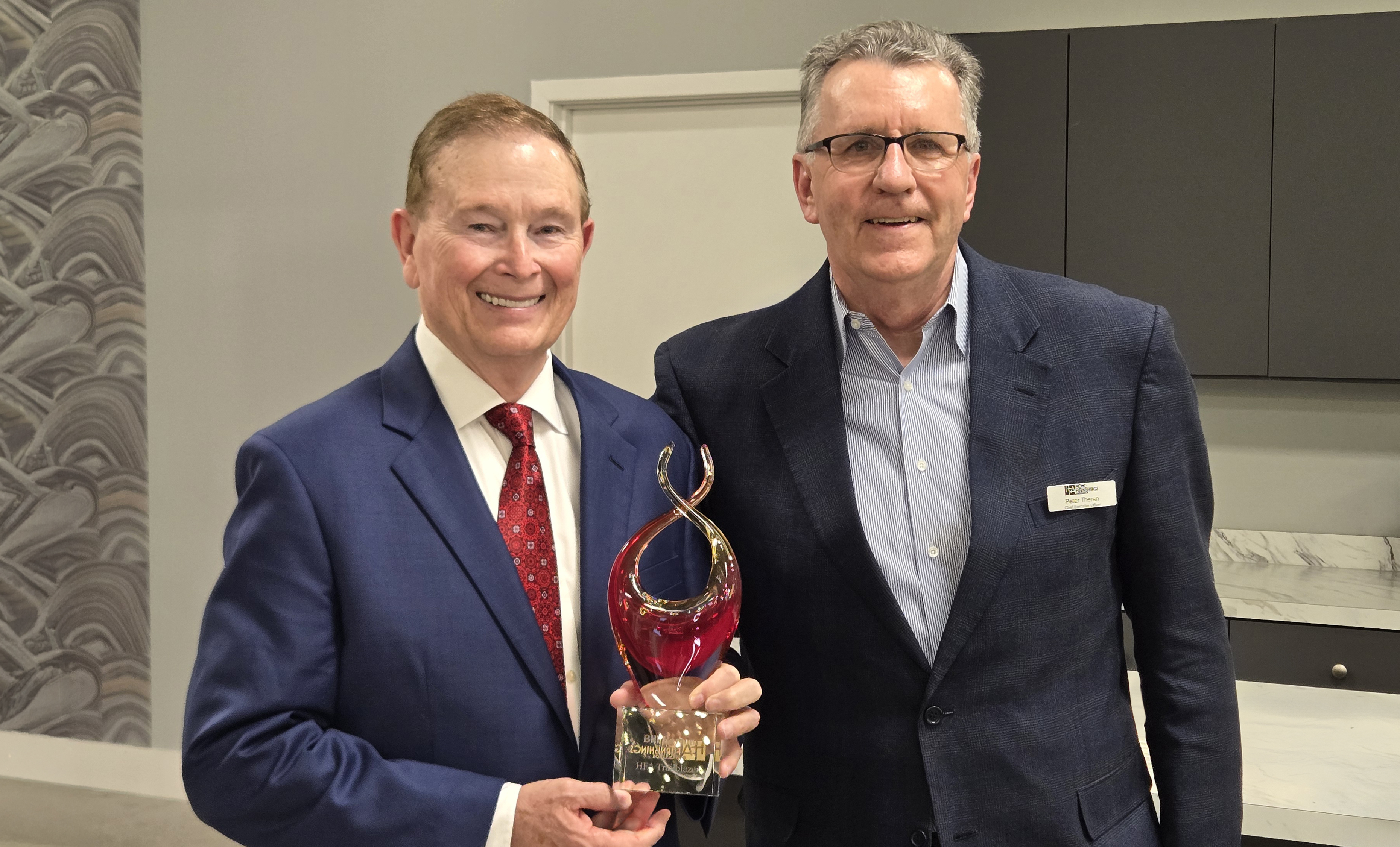 Bill Barton, left, accepts a glass award from Home Furnishings Association CEO Peter Theran