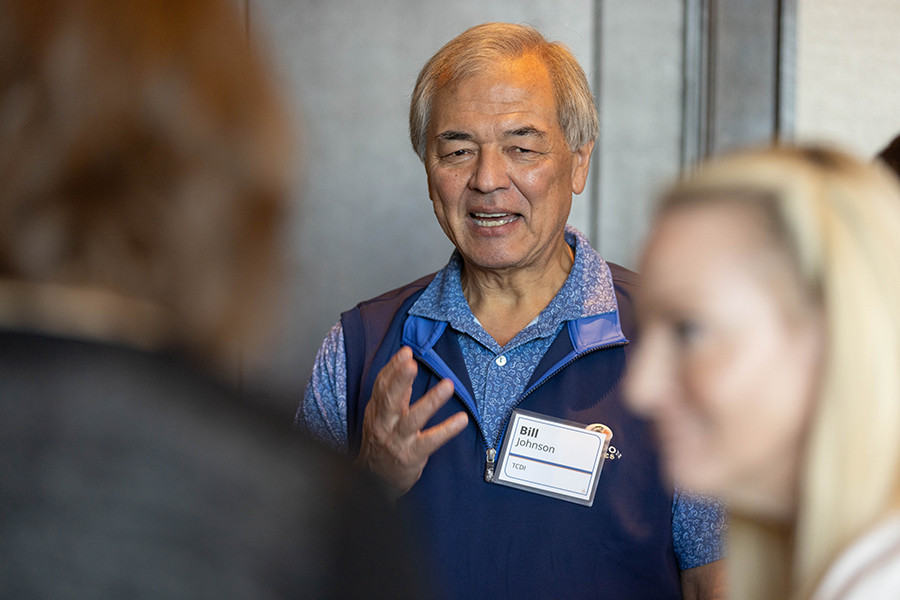 Bill Johnson talking with attendees, wearing a TCDI name badge