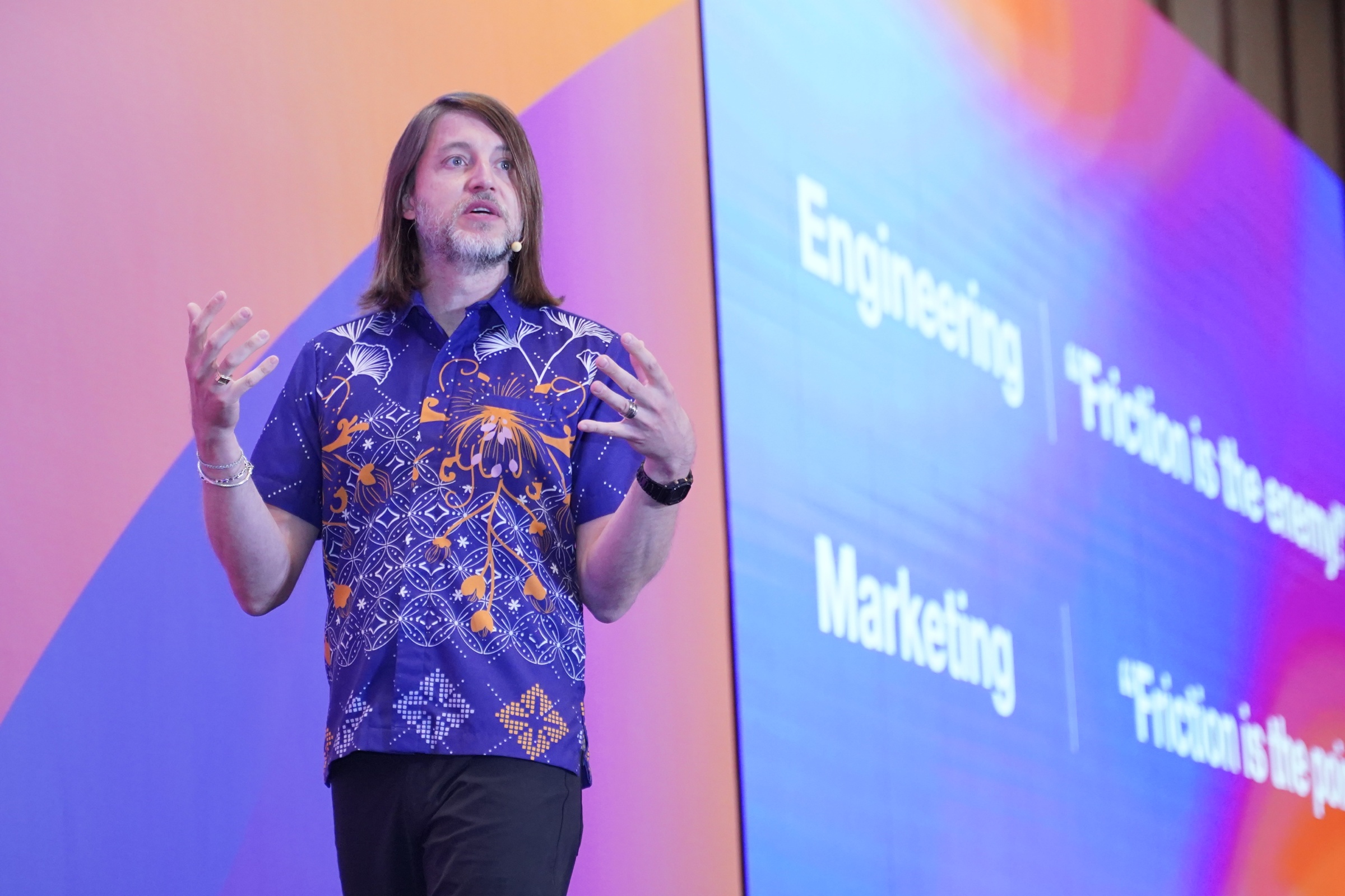 Bill Magnuson speaking at Grow with Braze Jakarta in a patterned blue shirt