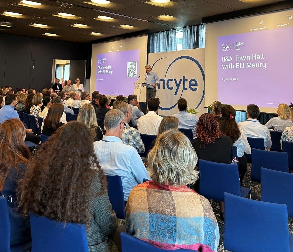 Bill Meury at a lectern addressing colleagues during an Incyte town hall in Switzerland