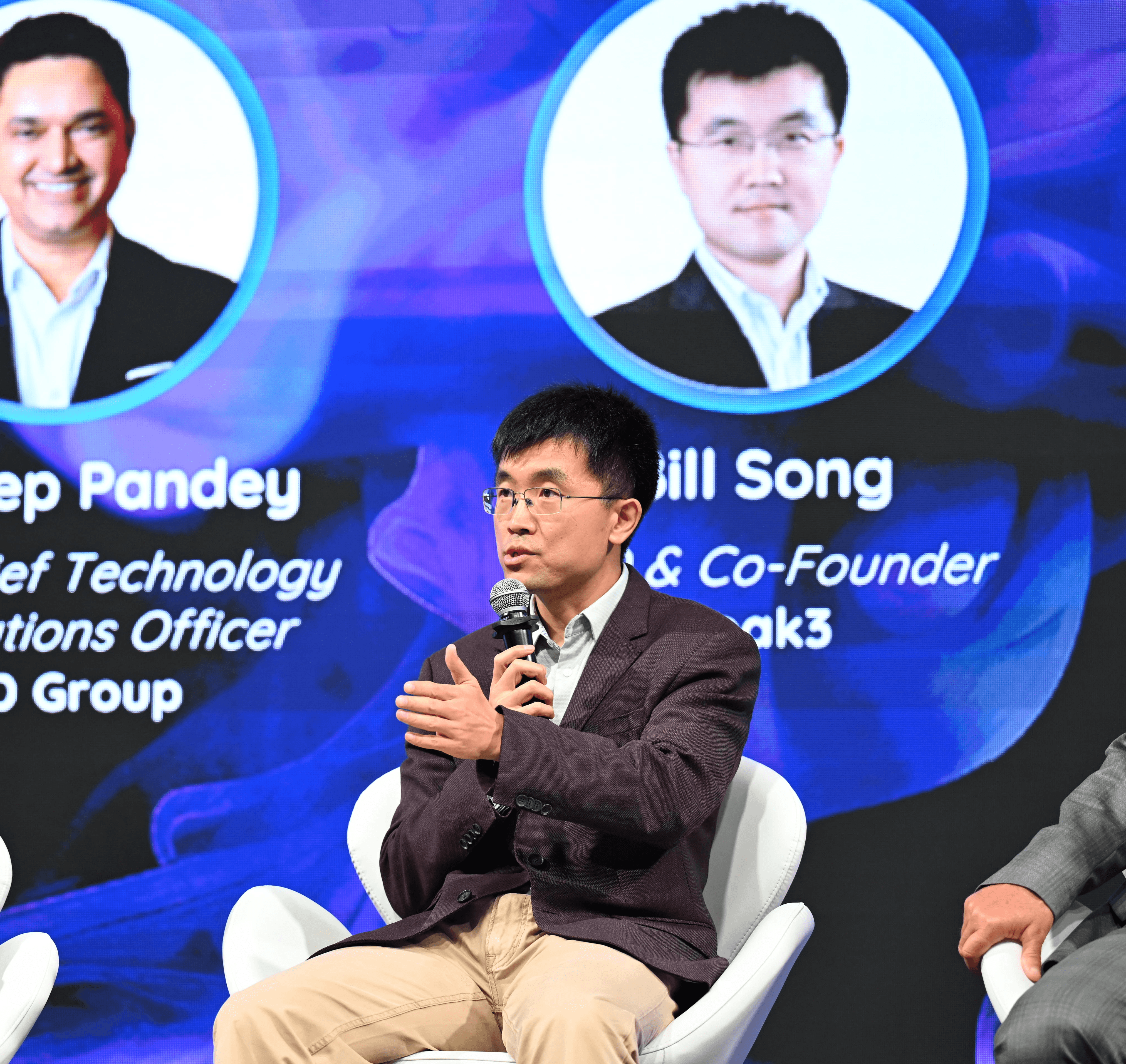 Bill Song speaking into a microphone during a panel discussion