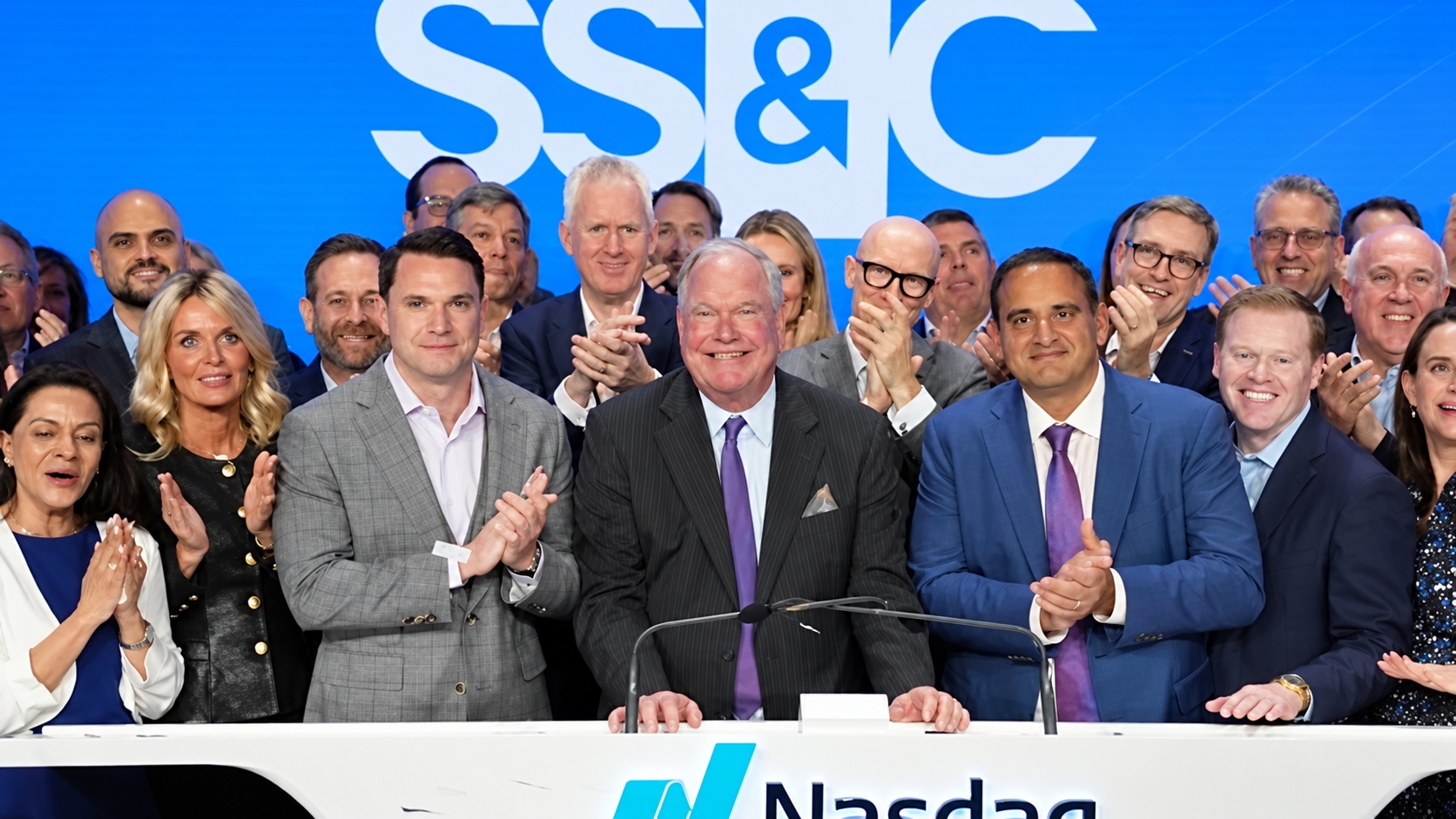 Bill Stone at the center of a group of SS&C colleagues at Nasdaq