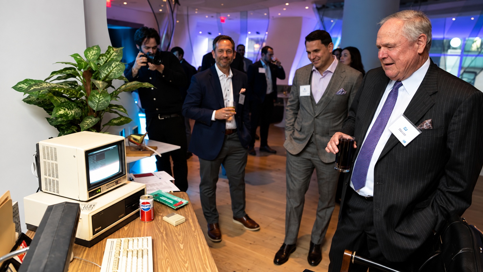 Bill Stone and colleagues looking at an older desktop computer at an SS&C event