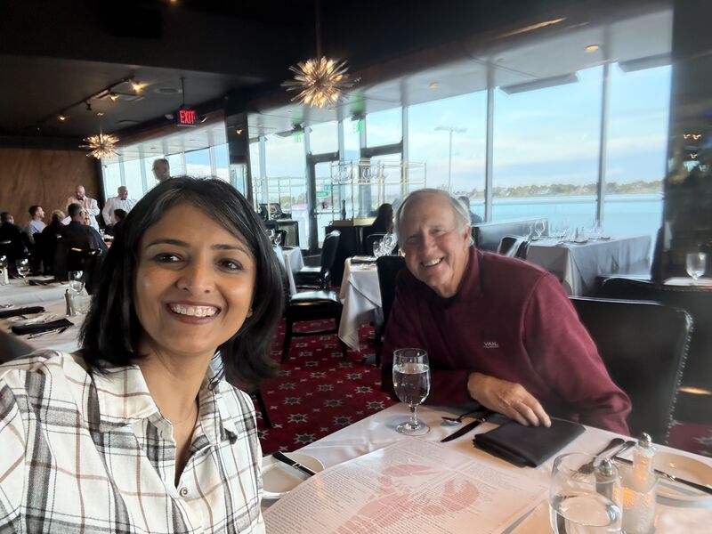 Bindiya Vakil and her longtime mentor Bill Hurles smiling across a restaurant table