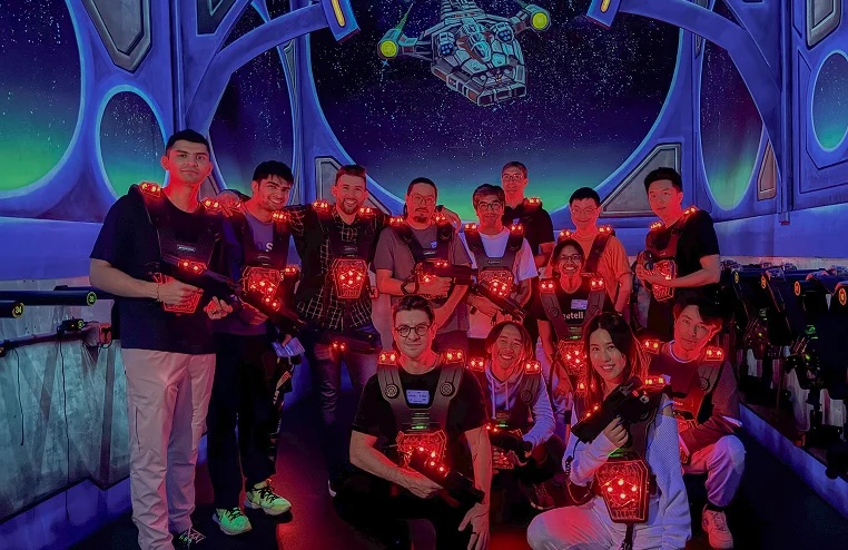 Retell team members posing together in laser-tag equipment