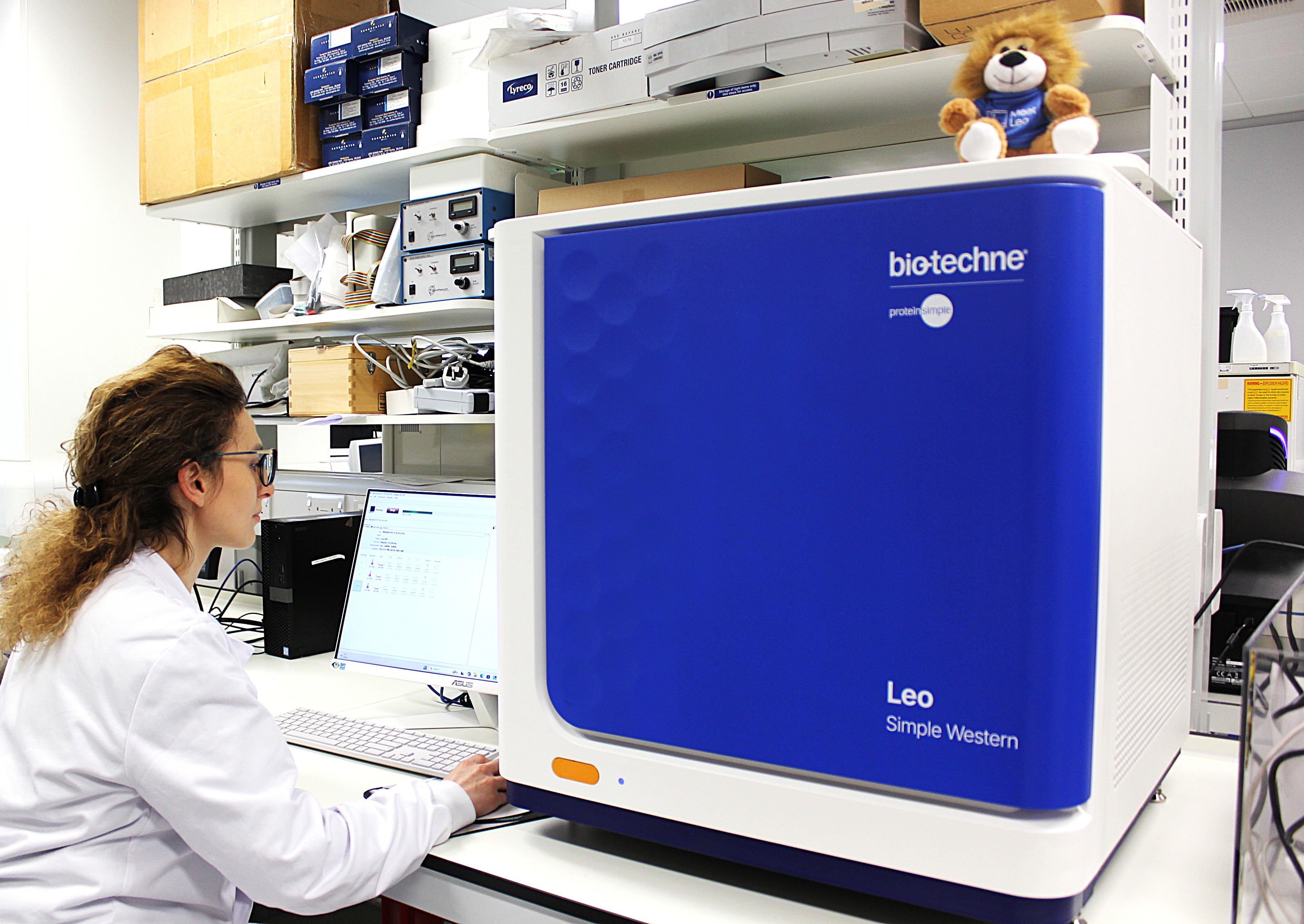 Researcher working beside a Bio-Techne Leo Simple Western instrument