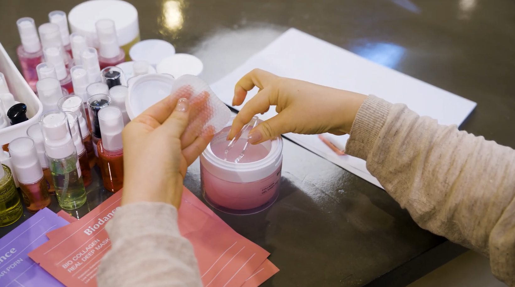 Hands testing a hydrogel toner pad at a Biodance development bench