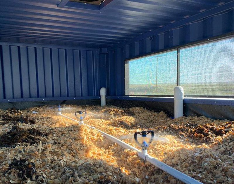 Sprinklers distributing wastewater across wood media inside a BioFiltro treatment module