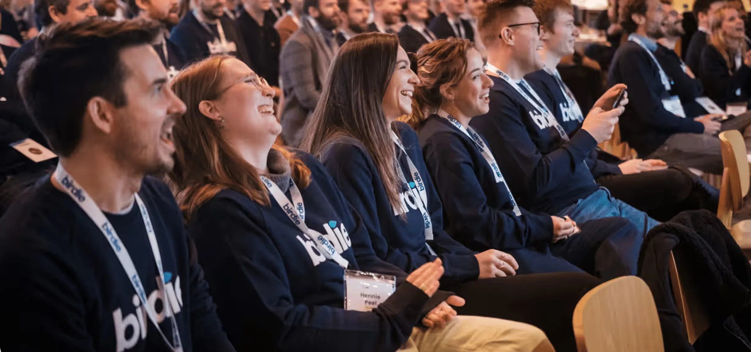 Birdie team members seated together at an event wearing Birdie clothing