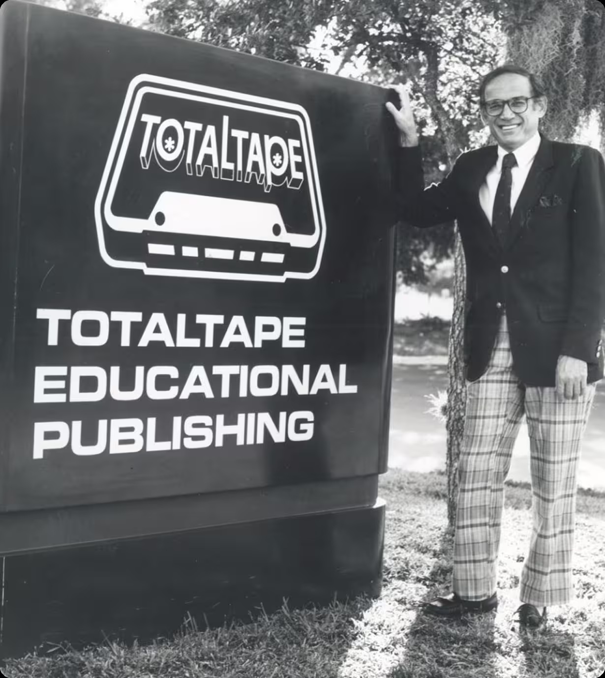 Nathan M. Bisk standing beside a TotalTape Educational Publishing vehicle