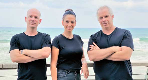 Bites co-founders Eran Heffetz, Tal Nagler Almog, and Hagai Horovitz standing beside the sea