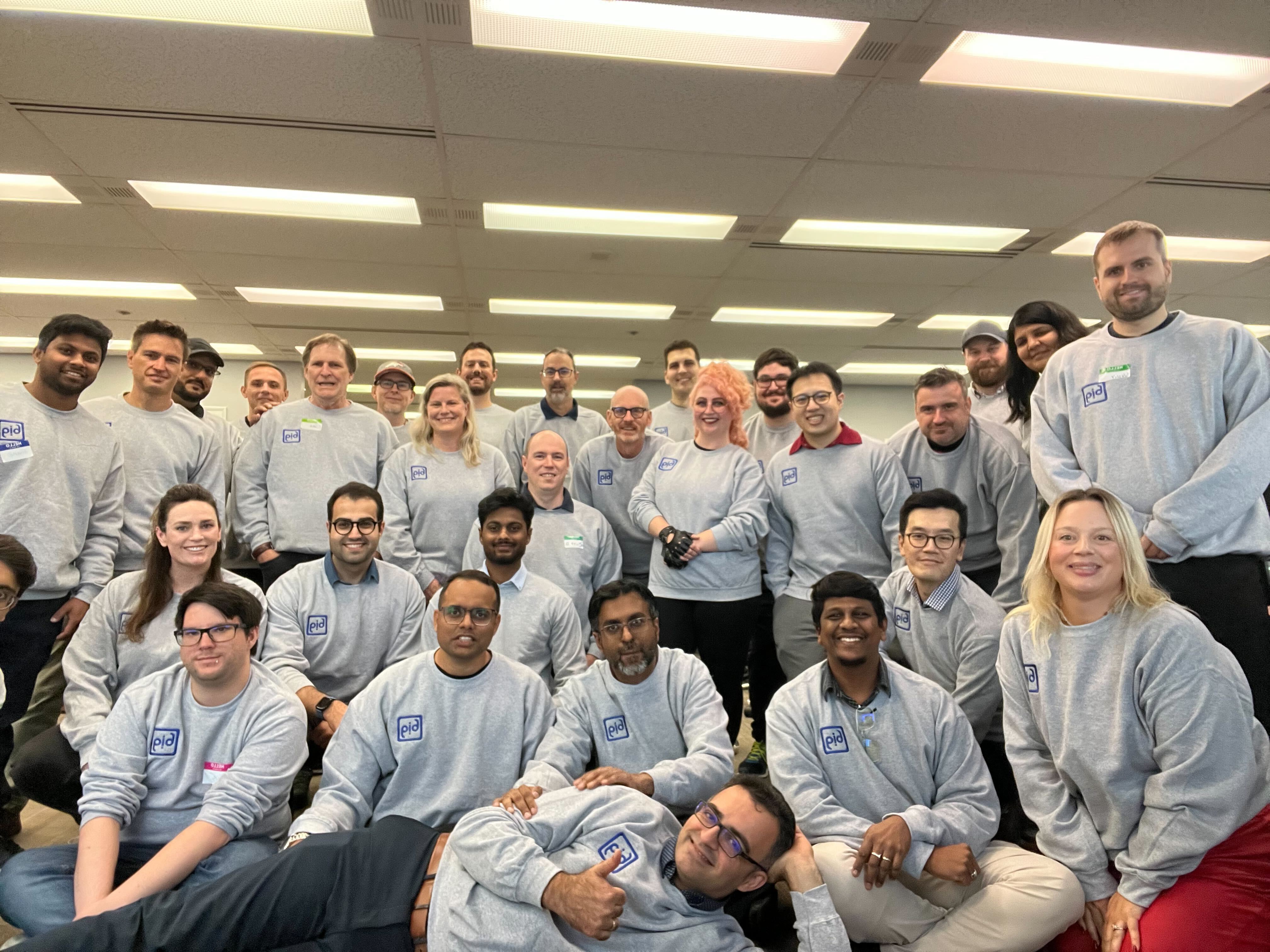 Bits In Glass team members posing together in a bright office