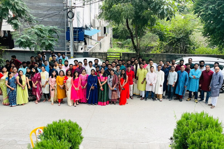 BizAcuity team members gathered outdoors in colorful clothing