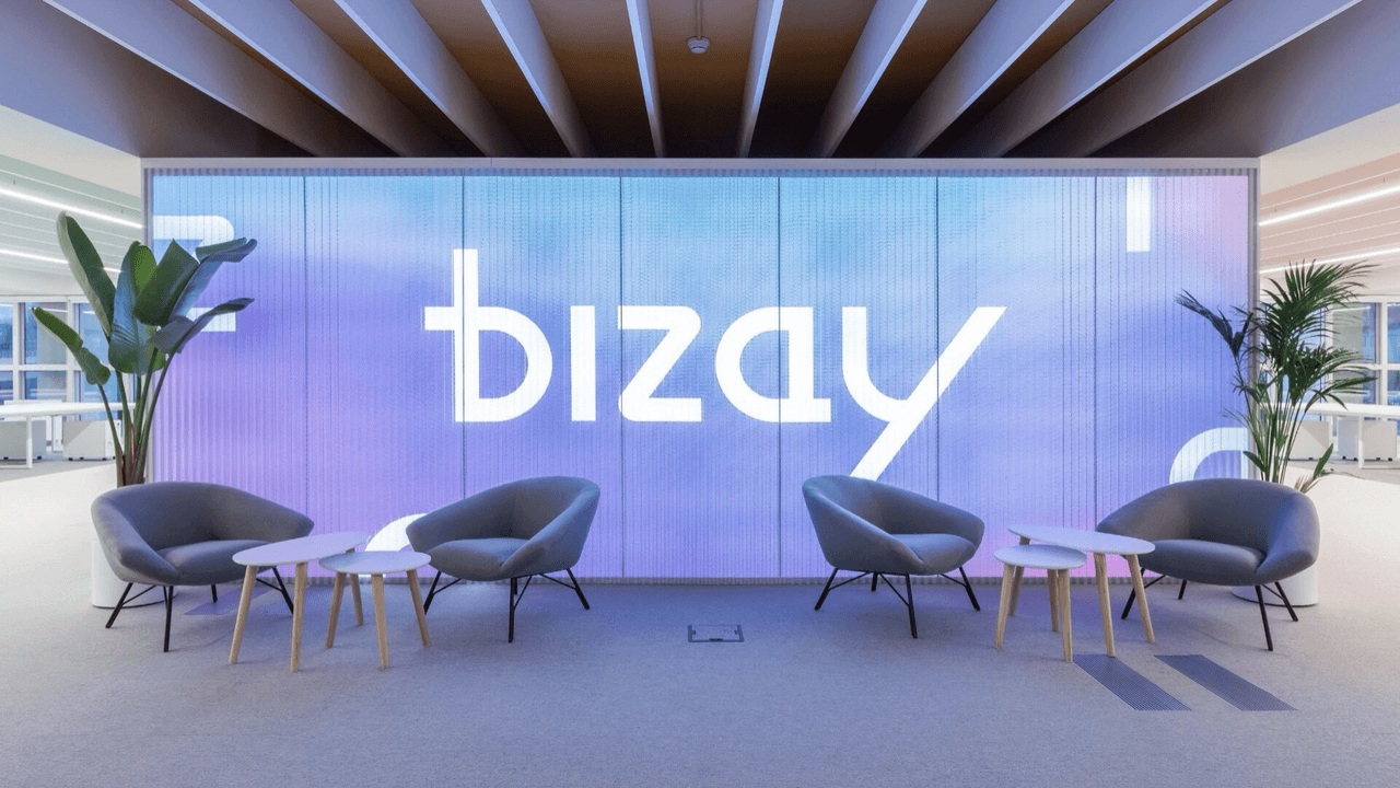 Historical BIZAY company image showing lounge chairs in front of an illuminated company sign