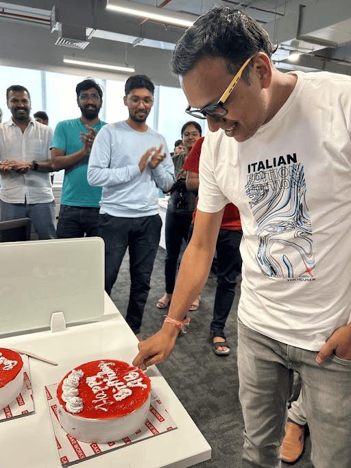 Blackstraw colleagues gathered around a cake during an office celebration