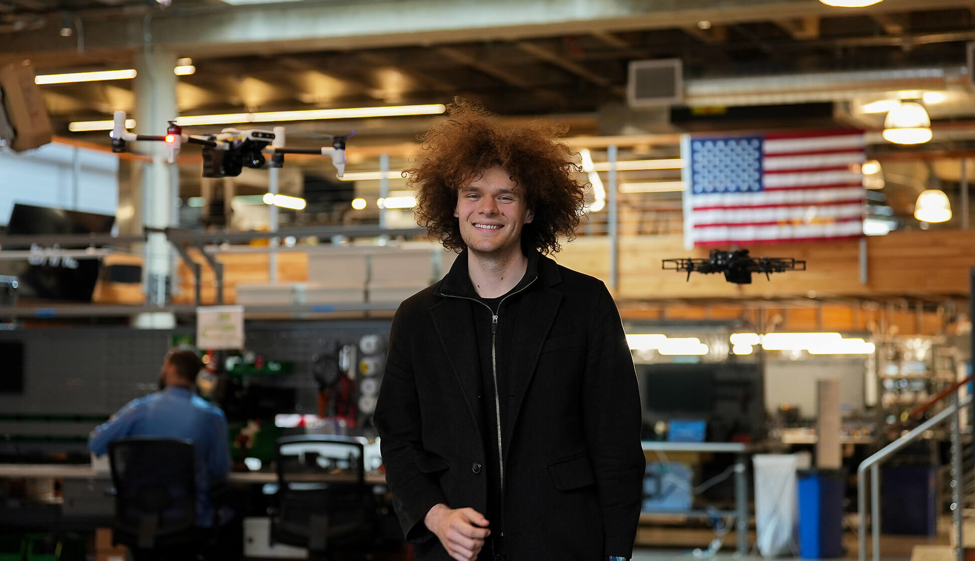 Blake Resnick standing in BRINC's Seattle workshop between two public-safety drones