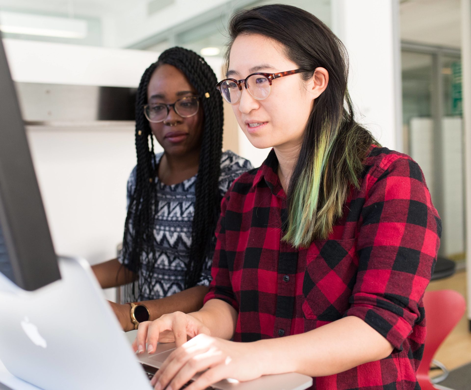 Two people collaborating at a desktop computer in an image from Blankfactor’s about page