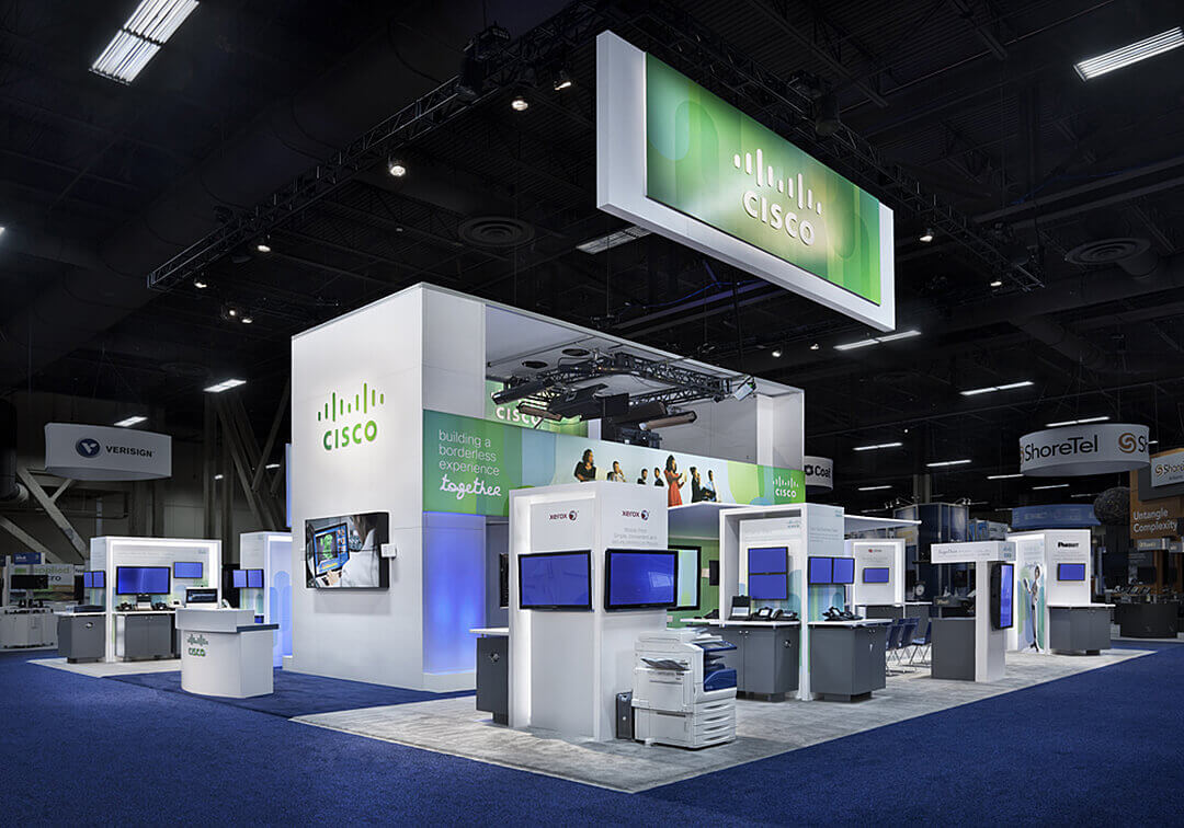 A large Cisco trade-show installation built by Blazer, with suspended signage and multiple demonstration stations