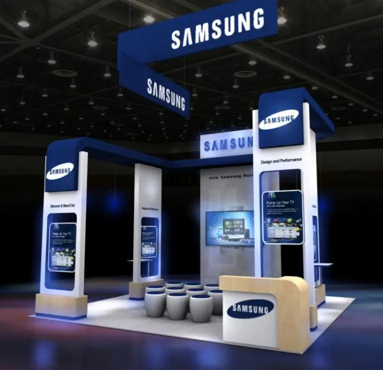 A Samsung trade-show booth by Blazer with overhead blue signs, interactive displays and seating