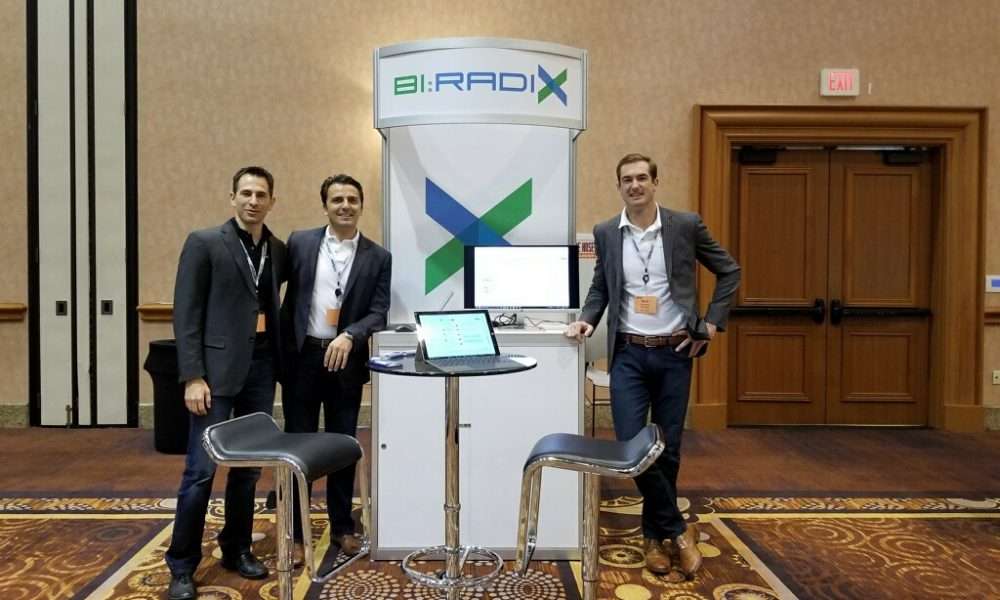 Blerim Zeqiri and the early BI:Radix team beside their conference booth