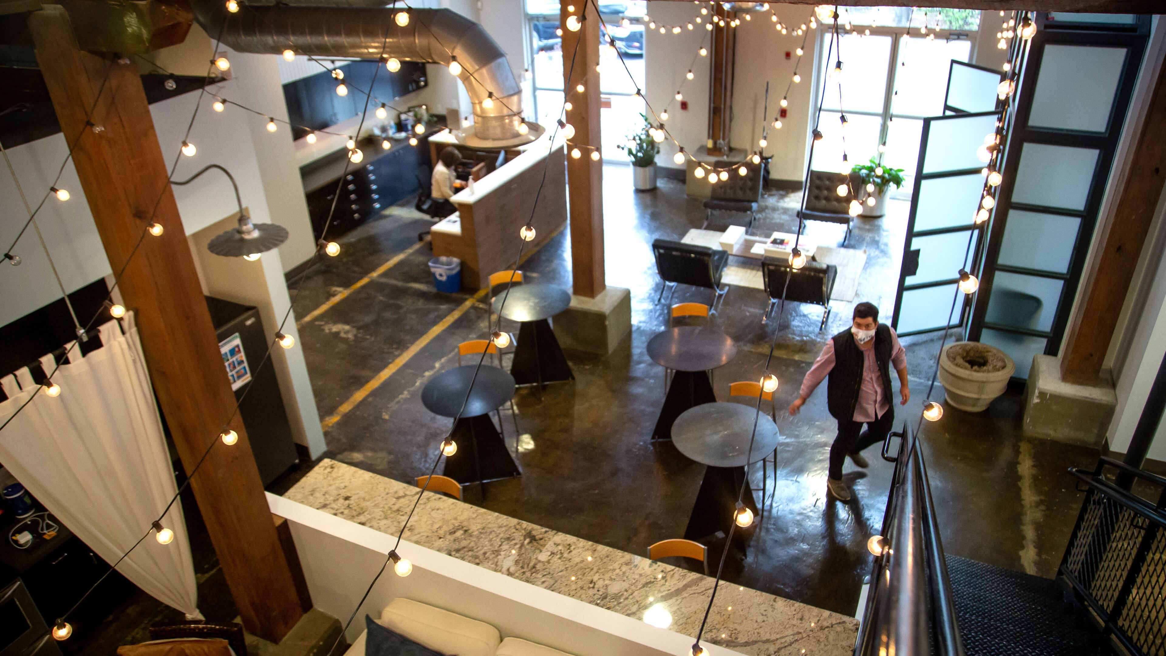 Blue Sky Agency's Atlanta office during the pandemic, with tables spaced apart and one masked employee walking through the room