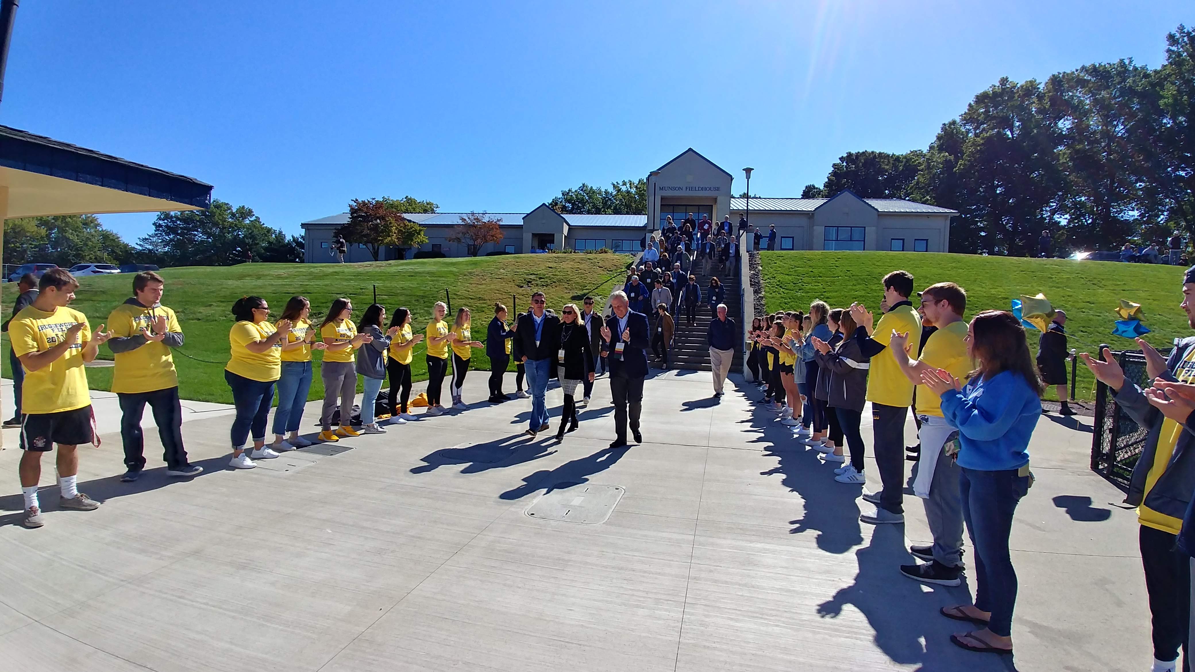 Students applaud Bob Bruggeworth and guests arriving for the Wilkes field dedication in 2019