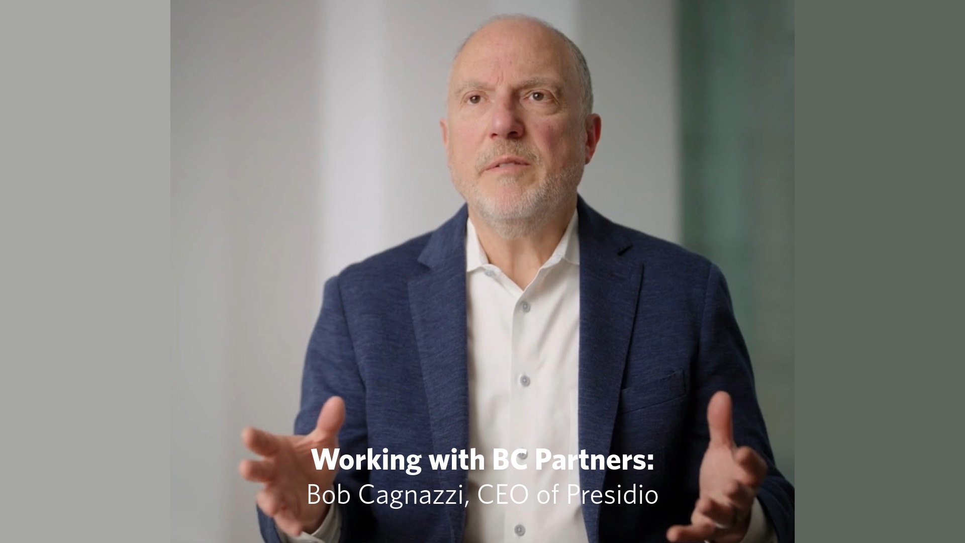Bob Cagnazzi gestures while speaking in a filmed interview about working with BC Partners.