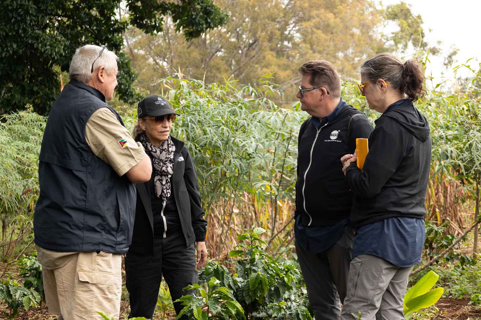 Bob and Michelle Fish, at right, talking with two people among coffee plants