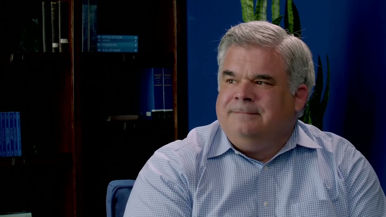 Bob Pritchett seated beside bookshelves during his conversation with Bill McCarthy