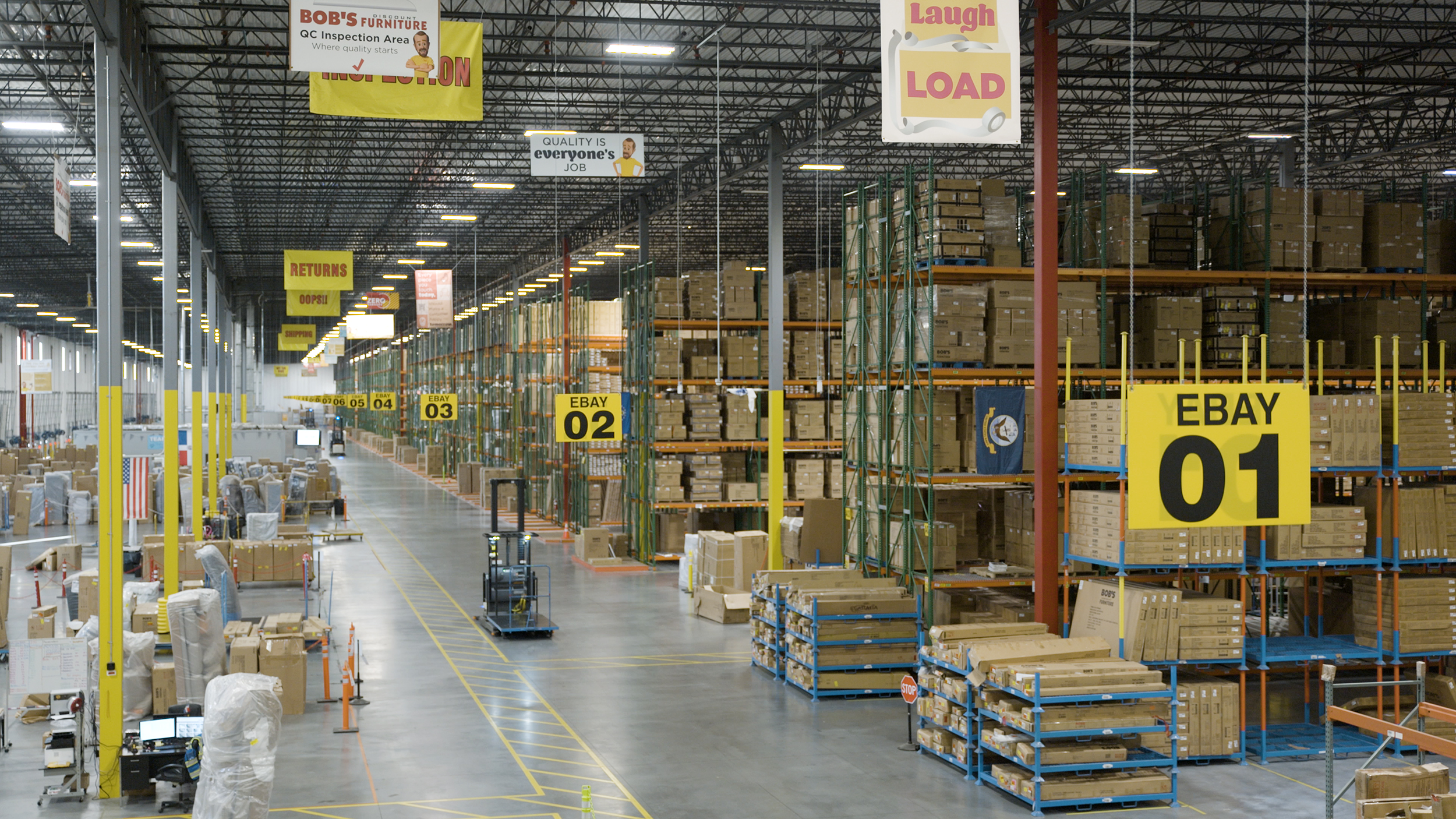 Tall racks of packaged furniture inside Bob’s Piscataway distribution center