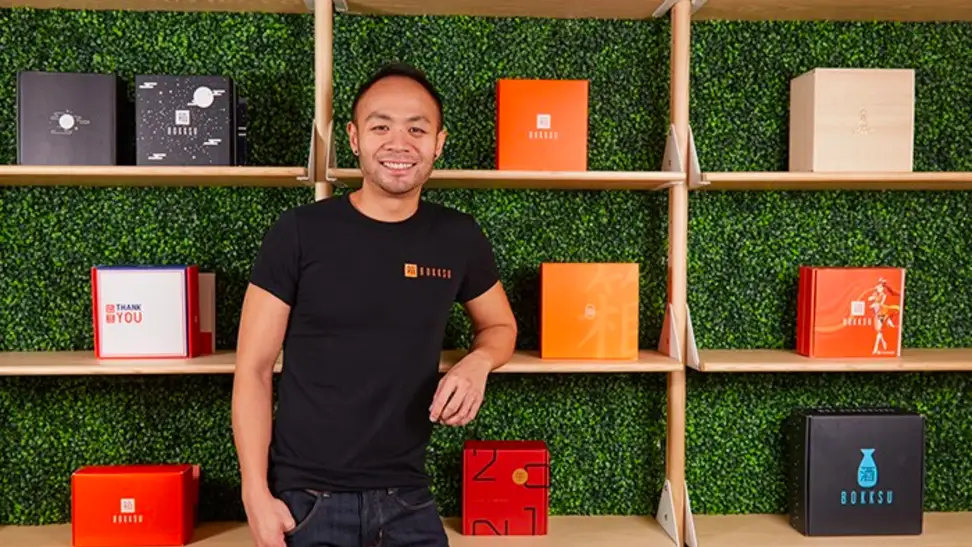 Bokksu founder Danny Taing standing in front of stacks of Bokksu boxes