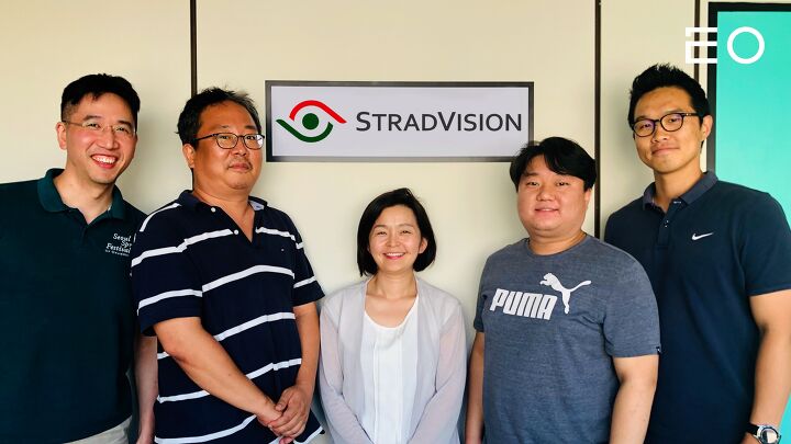Five STRADVISION colleagues stand beneath the company sign; Bongjin Jun is second from left