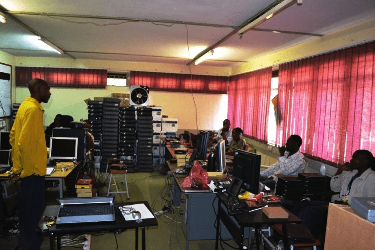 BongoHive’s early workspace, with red blinds, desktop computers and people working around tables