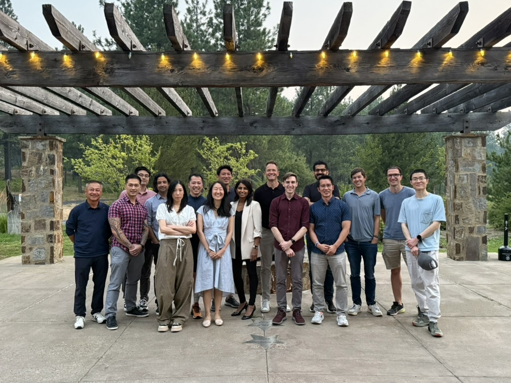 Members of the Vayo team standing outdoors beneath a timber pergola