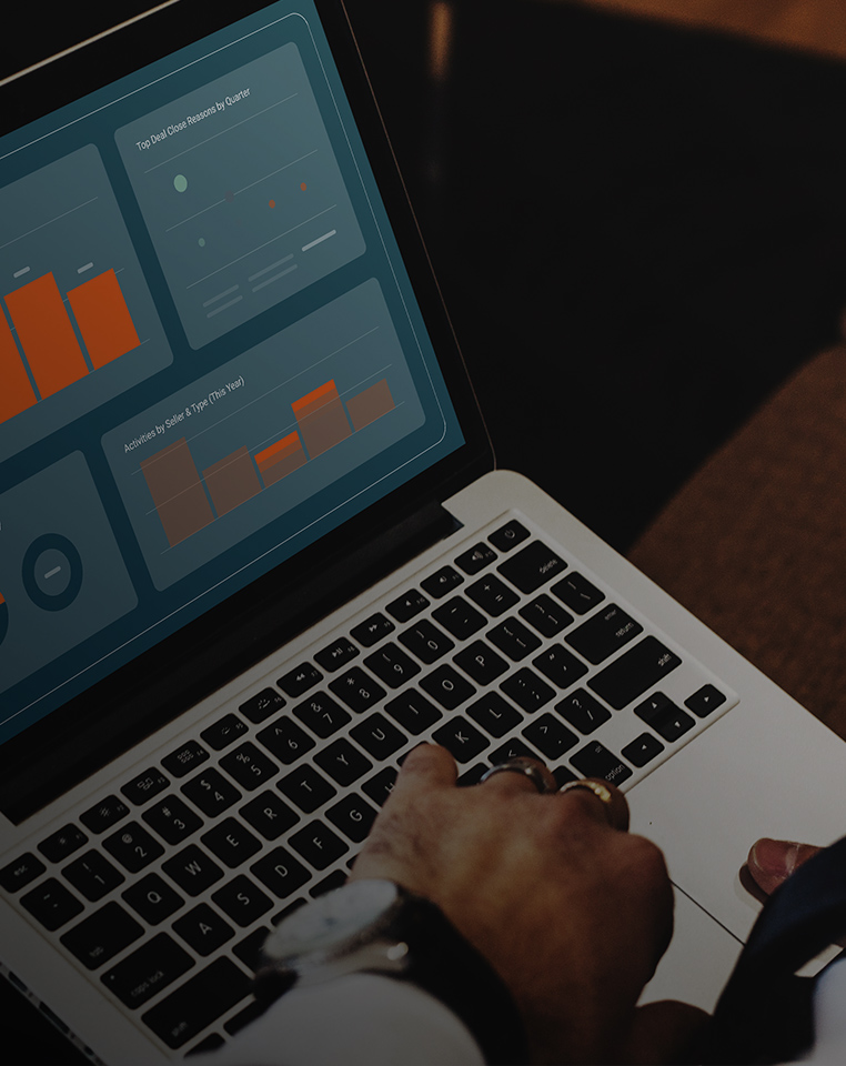 Boostr CRM marketing image showing a laptop with revenue dashboards