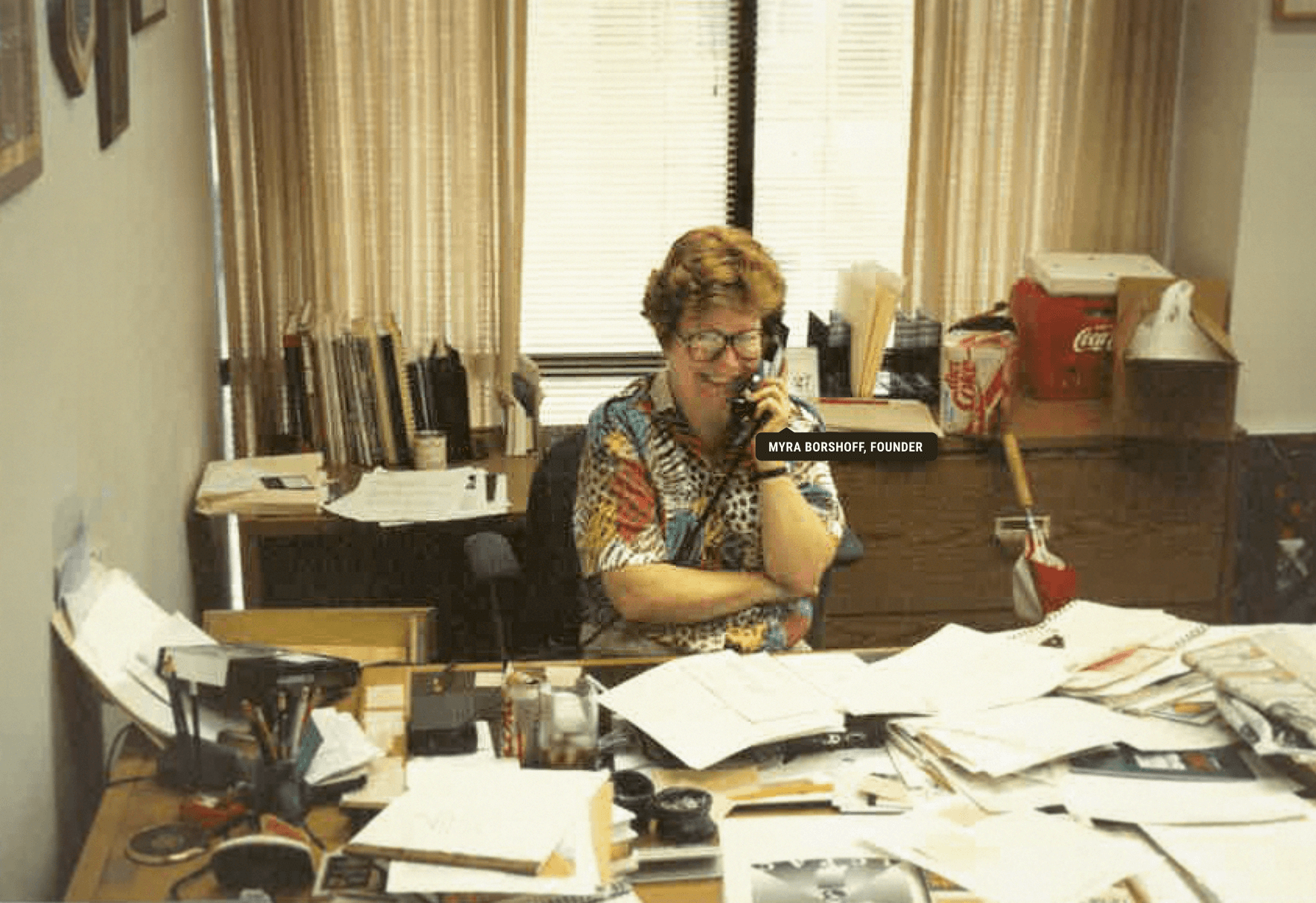 Myra Borshoff at a crowded desk in the agency's early years