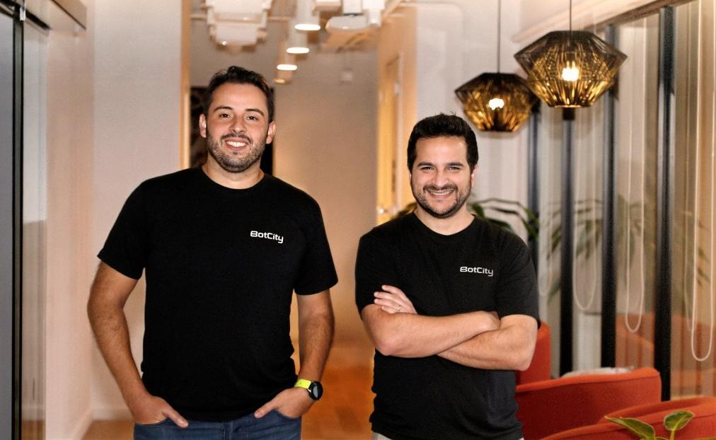 BotCity cofounders Gabriel Archanjo and Lorhan Caproni standing together in an office
