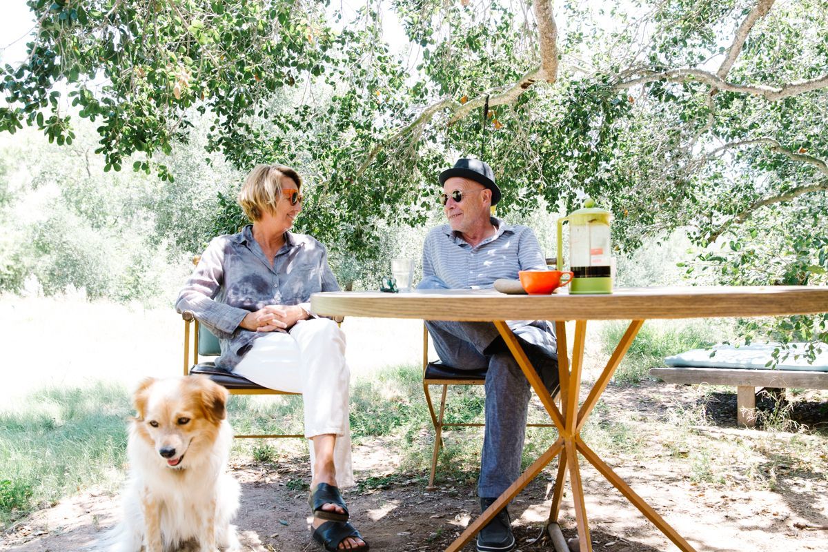 Veronique Lievre and Heinz Legler seated outdoors with a dog in the foreground
