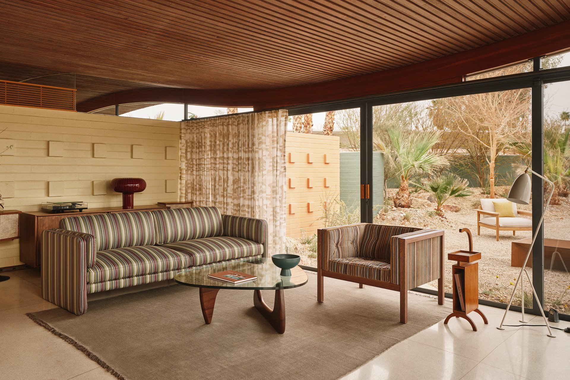 Desert Wave living room with patterned modern furniture, orange curtains and a curved timber ceiling