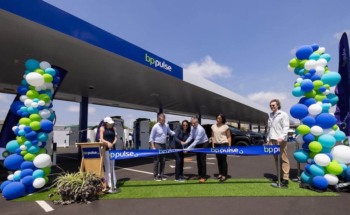 A group cuts the ribbon beneath the canopy at bp pulse’s LAX charging hub.